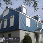 white rolling shutters on a blue home