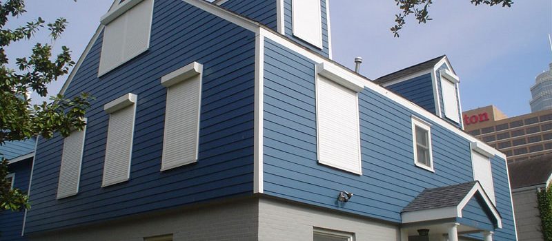 white rolling shutters on a blue home